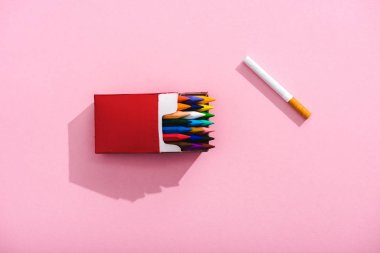 pembe, sigara kavramı üzerinde sigara paketi ve tütün sigara renkli boya kalemleri üst görünümü