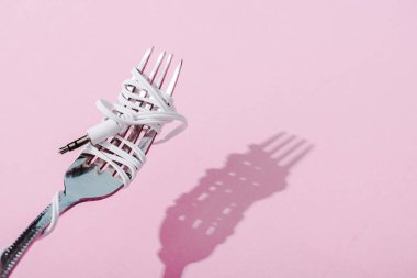 fotokopi alanı ile pembe metal çatal üzerine sarılmış kulaklıklar, müzik konsepti