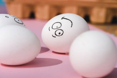 pembe üzerinde gülümseyen yüz ifadesi ile yumurta seçici odak
