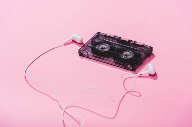 vintage audio cassette with earphones on pink, music concept clipart