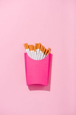 kopya alanı ile pembe kağıt kutusuna paketlenmiş sigara üst görünümü, patates kızartması kavramı
