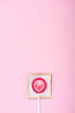 kopya alanı ile pembe lolipop olarak sarılmış prezervatif üst görünümü, Güvenli Seks kavramı