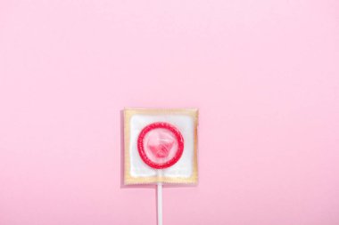 kopya alanı ile pembe lolipop olarak sarılmış prezervatif üst görünümü, Güvenli Seks kavramı