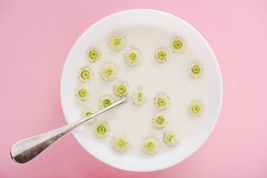 pembe yulaf lapası ile kase de kaşık ve krizantem çiçek üst görünümü