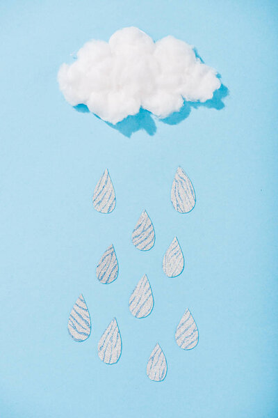 top view of cotton candy cloud with glitter raindrops on blue