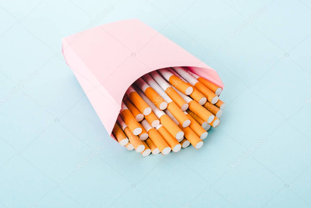 cigarettes packed in paper box isolated on blue, french fries concept