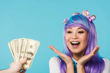 Dolar banknotlar tutan adam kırpılmış görünümü ve mavi izole heyecanlı asya anime kız