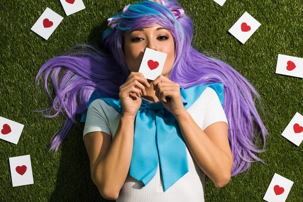 Asian Anime Girl Purple Wig Holding Card Lying Grass — Stock Photo, Image