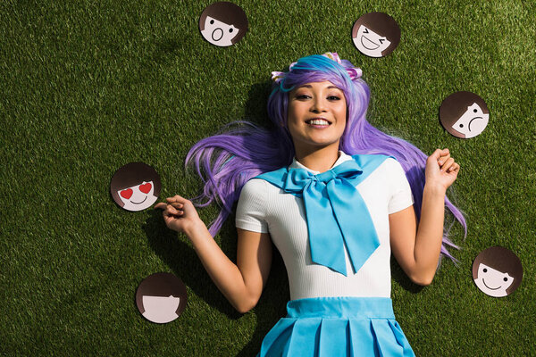 Asian anime girl in purple wig with emoticons lying on grass