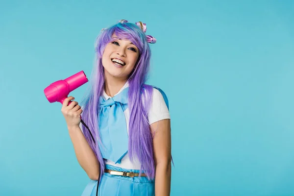 Sorridente Asiatico Anime Ragazza Parrucca Utilizzando Asciugacapelli Isolato Blu — Foto Stock