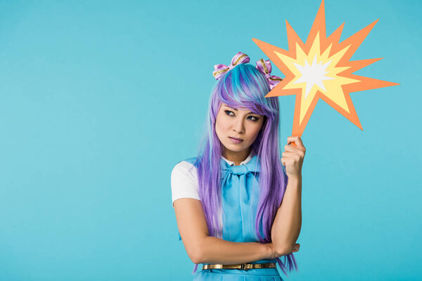 dissatisfied asian anime girl in wig looking away isolated on blue