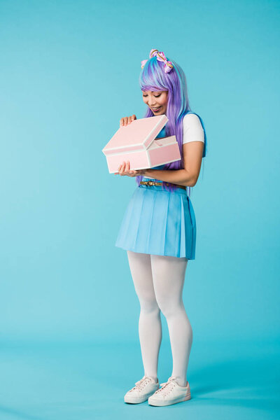 Full length view of anime girl in purple wig holding briefcase on blue