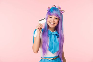 Pembe izole kredi kartı tutan mor peruk gülümseyen asya anime kız