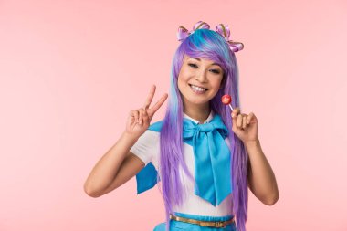 Mutlu asya anime kız lolipop tutan ve pembe izole barış işareti gösteren