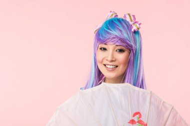 Pembe izole kağıt şemsiye tutan peruk gülümseyen asya anime kız