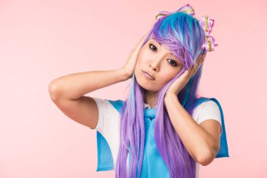 Sad asian anime girl in purple wig touching head and looking at camera clipart