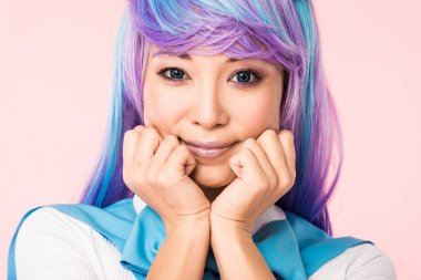 Smiling asian anime girl in wig posing isolated on pink clipart