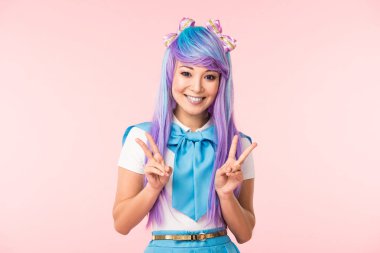 Pembe izole barış işaretleri gösteren mor peruk neşeli asya anime kız