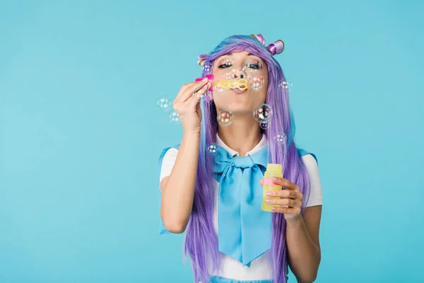 亚洲动漫女孩在紫色假发与肥皂泡隔离在蓝色 — 图库照片