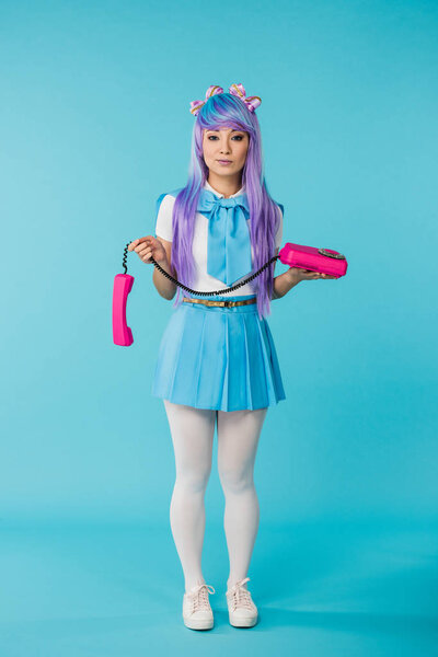 Full length view of asian anime girl with telephone on blue