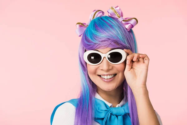 微笑的动漫女孩在假发和太阳镜隔离在粉红色 — 图库照片