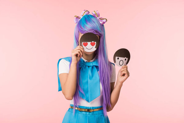 Anime girl in purple wig holding emoticons isolated on pink