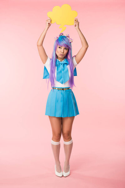 Full length view of asian anime girl holding thought bubble on pink