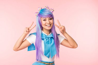 Pembe izole barış işaretleri gösteren mor peruk neşeli asya anime kız