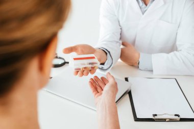 hastaya hap veren beyaz ceketli doktorun kırpılmış görünümü 