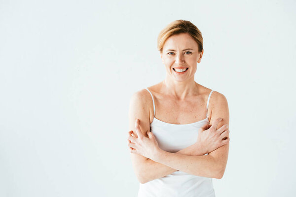 attractive woman with skin disease smiling while scratching skin isolated on white 