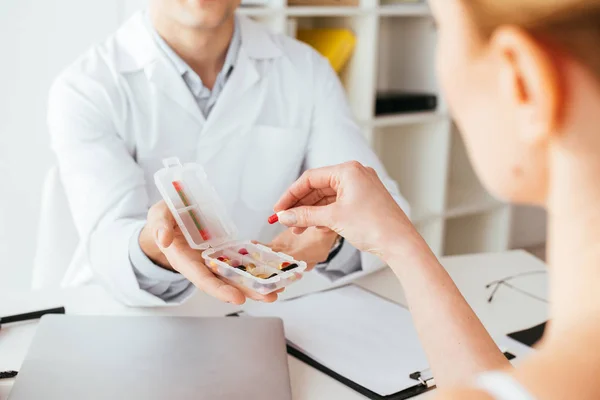 Kadın Yakın Hapları Ile Kutu Tutan Doktor Kırpılmış Görünümü — Stok fotoğraf