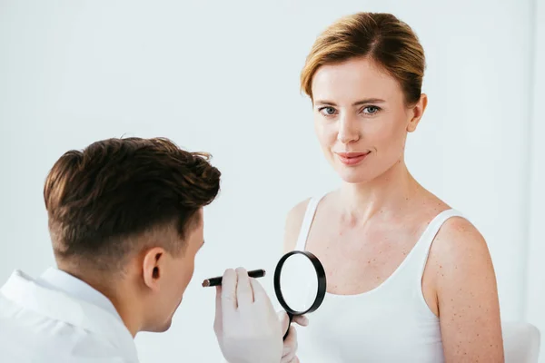 Dermatoloog Die Vergrootglas Vasthoudt Tijdens Het Onderzoeken Van Aantrekkelijke Vrouw — Stockfoto