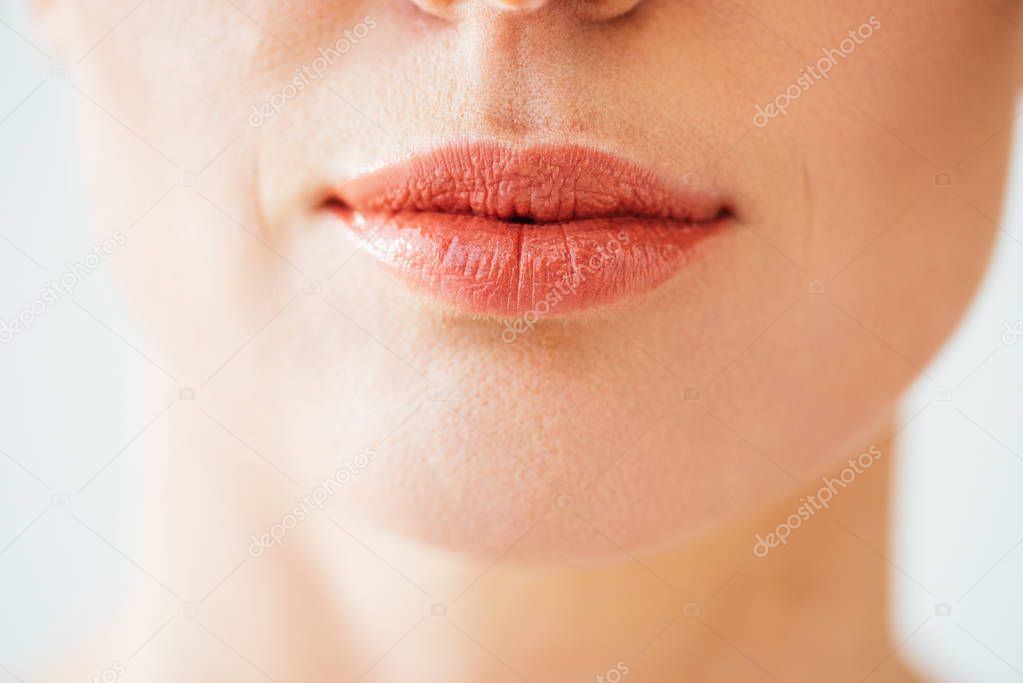 cropped view of herpes on lips of woman isolated on white