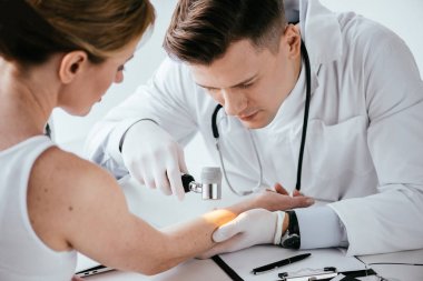 dermatolog seçici odak dermatofoskop ile kadının elini muayene 