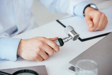 klinikte dermatoskop tutan dermatolog kırpılmış görünümü 