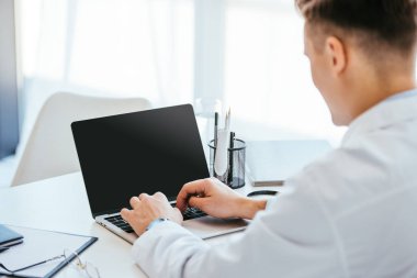 boş ekranlı dizüstü bilgisayar kullanan doktorun seçici odak noktası 