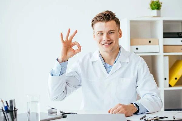 Χαρούμενος Γιατρός Λευκό Παλτό Δείχνει Υπογράψει Στην Κλινική — Φωτογραφία Αρχείου