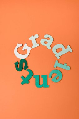 top view of colorful letters on orange surface clipart