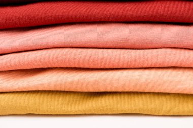 beyaz yüzeyüzerinde katlanmış renkli giysiler yığını