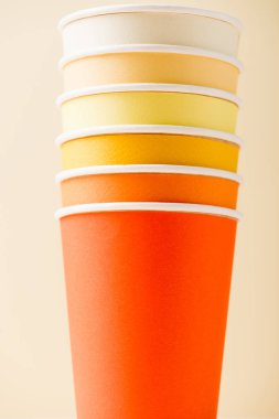 bright colorful disposable cups isolated on beige background clipart