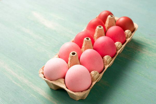 painted easter eggs in cardboard carrier on textured surface