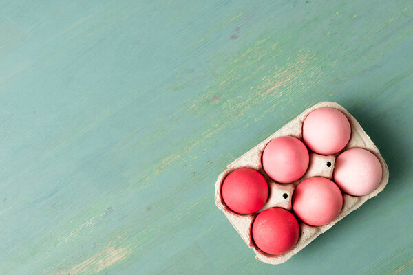 top view of painted easter eggs in cardboard carrier on textured surface
