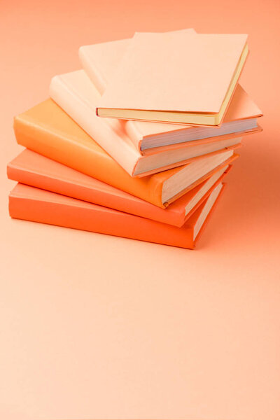 stack of colorful hardcover books on orange surface