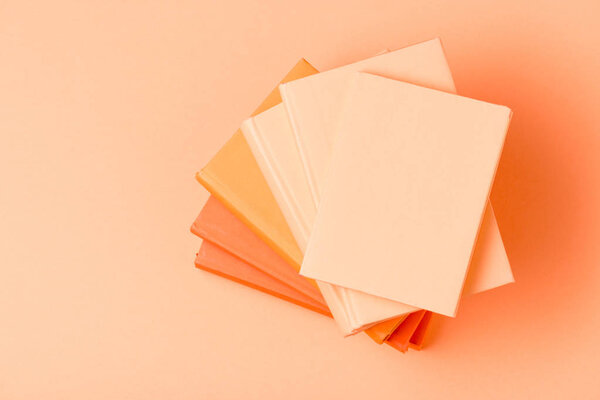 top view of stack of colorful books on light surface