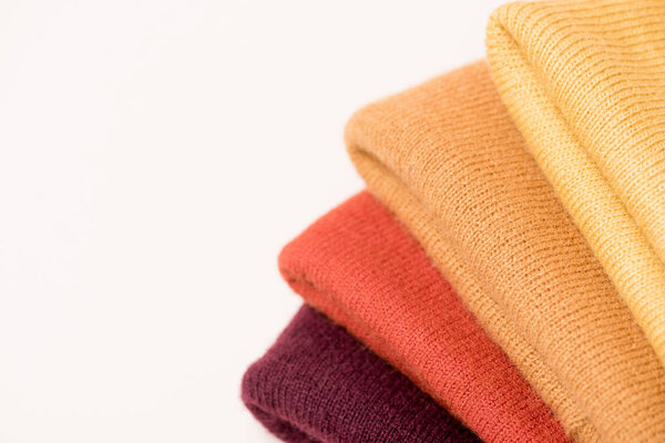 stack of folded colorful clothes on white surface