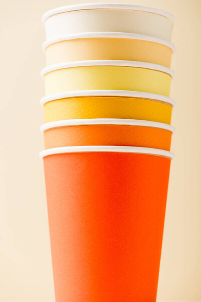 bright colorful disposable cups isolated on beige background