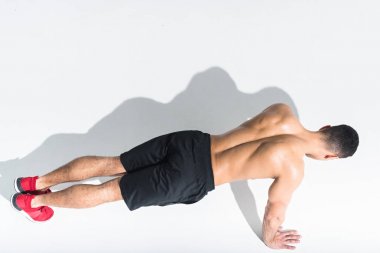 overhead view of shirtless athletic man doing push ups on white clipart