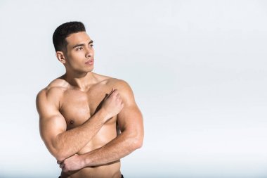 kaslı gövdeile iyi görünümlü sportif adam beyaz uzağa bakıyor