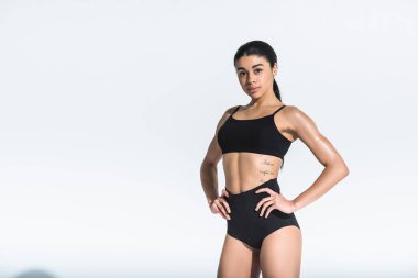 güzel sportif afro-amerikan kız kalçael ele tutuşarak ve beyaz kamera bakıyor