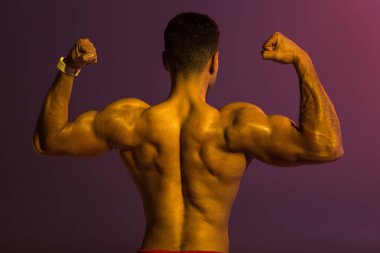 mor arka plan üzerinde pazı gösteren kas gövde ile atletik adam arka görünümü